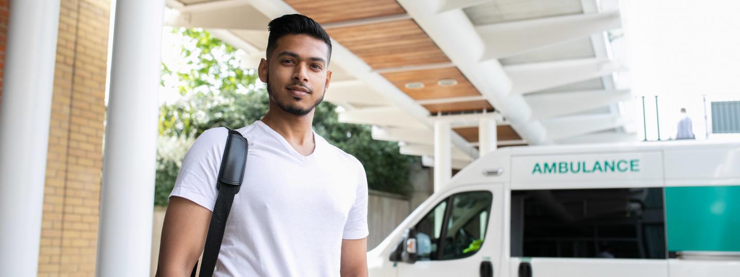 Man stood in front of an ambulance